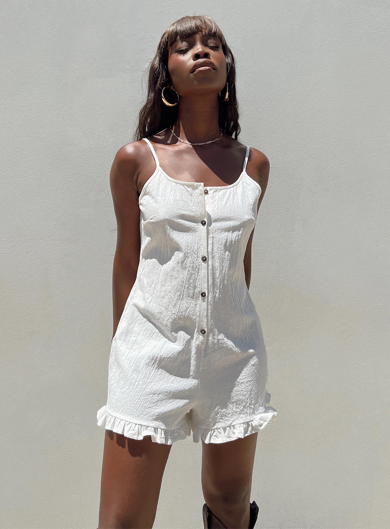Playsuit Adjustable shoulder straps Scooped neckline Button fastening at front Frill hem Non-stretch