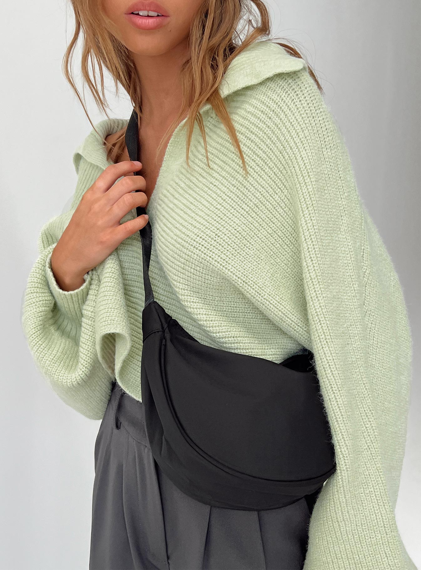 Black crossbody bag Nylon material Adjustable strap Zip fastening Internal slip pocket Silver toned hardware