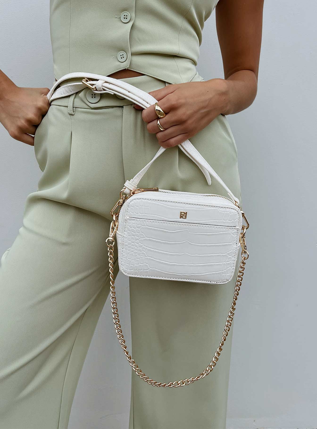 Crossbody bag 40% post-consumer recycled polyester 18% post-consumer recycled polyurethane 18% polyurethane 14% calcium carbonate 10% wood fiber Faux croc leather  Removable chain shoulder strap  Removable / adjustable crossbody strap  Zip fastening  Internal pockets  Flat base 