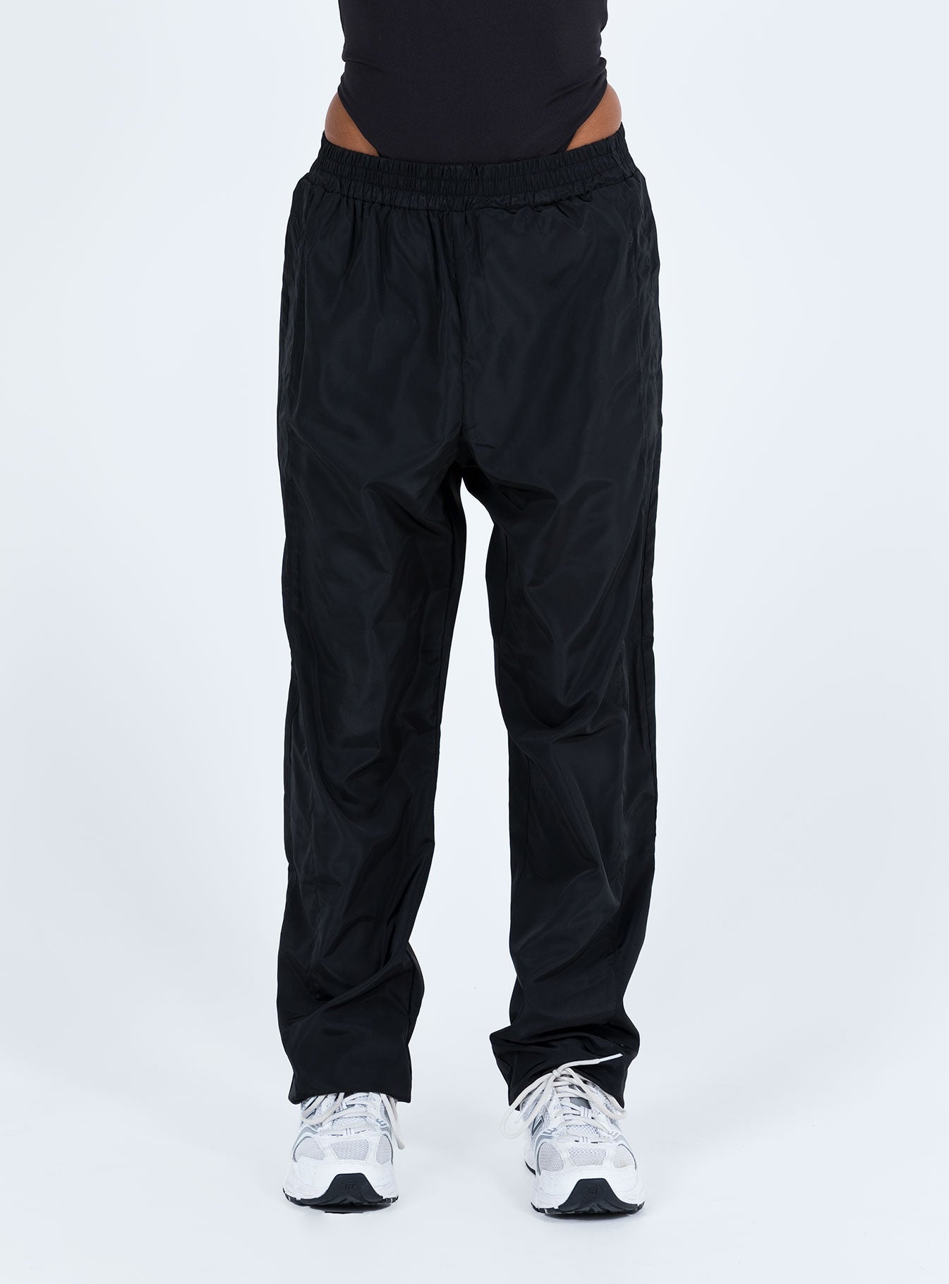 Black pants Windbreaker material Elasticated waistband Twin hip pockets Elasticated cuffs