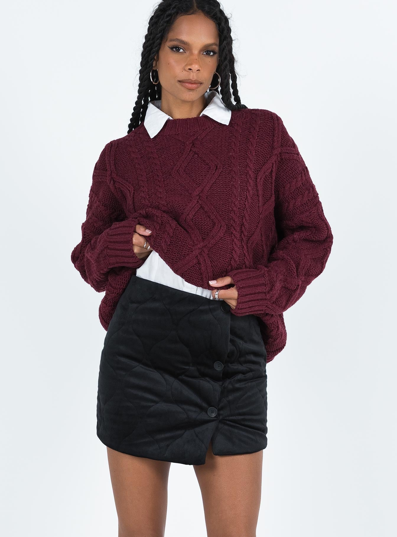 Black mini skirt Quilted material High rise Invisible zip fastening at back Button detail at front