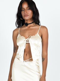 Cami top Silky material Adjustable shoulder straps Lace trim Scooped neckline Lace up fastening at bust Split hem