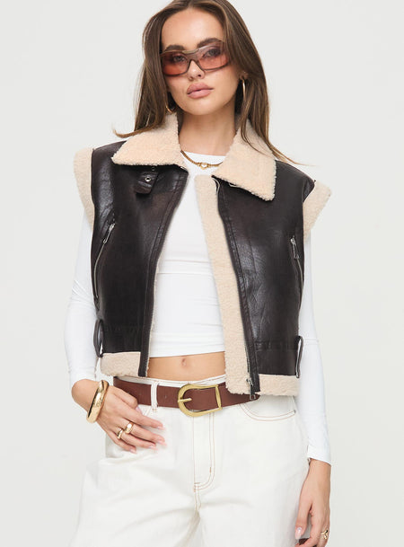 Shearling vest Faux leather, classic collar, exposed zip fastening, belt looped waist, twin pockets with zip closure Non-stretch material, shearling lining