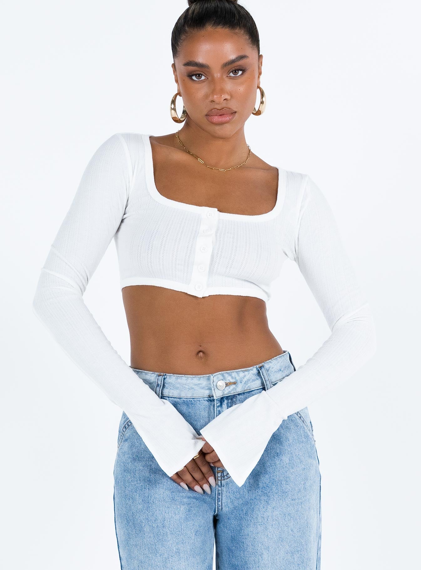 White long sleeve top Thin knit material Cropped design Scoop neck Front button fastening Flared sleeves Good Stretch Unlined 