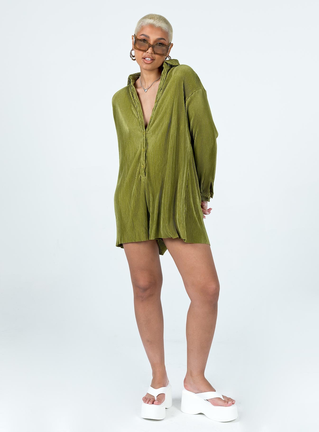 Green romper Silky material  Pleated design  Classic collar  Button front fastening  Drop shoulder  Button fastening at cuffs Raw cut hem 