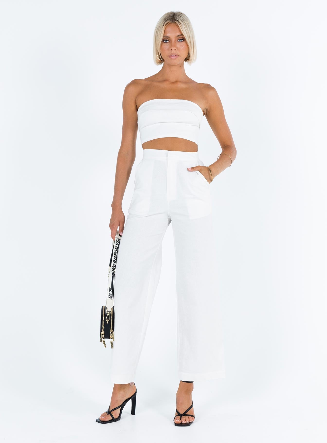 White matching set Linen look material Strapless crop top Folded neckline Inner silicone strip at bust Zip fastening at back High waisted pants Front button and zip fastening  Twin hip pockets
