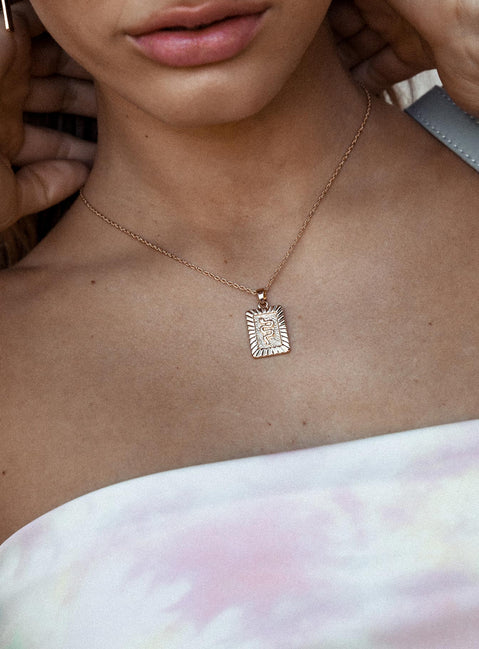 Necklace Drop charm with snake detail Dainty rope chain Gold toned hardware Lobster clasp fastening