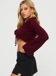 Long Sleeve Top Knit material, V-neckline, crop style rosette detail, flared sleeves, tie fastening at bust