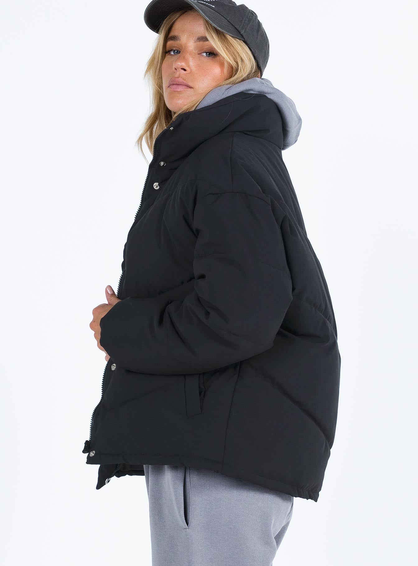 Black puffer jacket High neck Zip front fastening Twin zip front pockets Ribbed cuffs