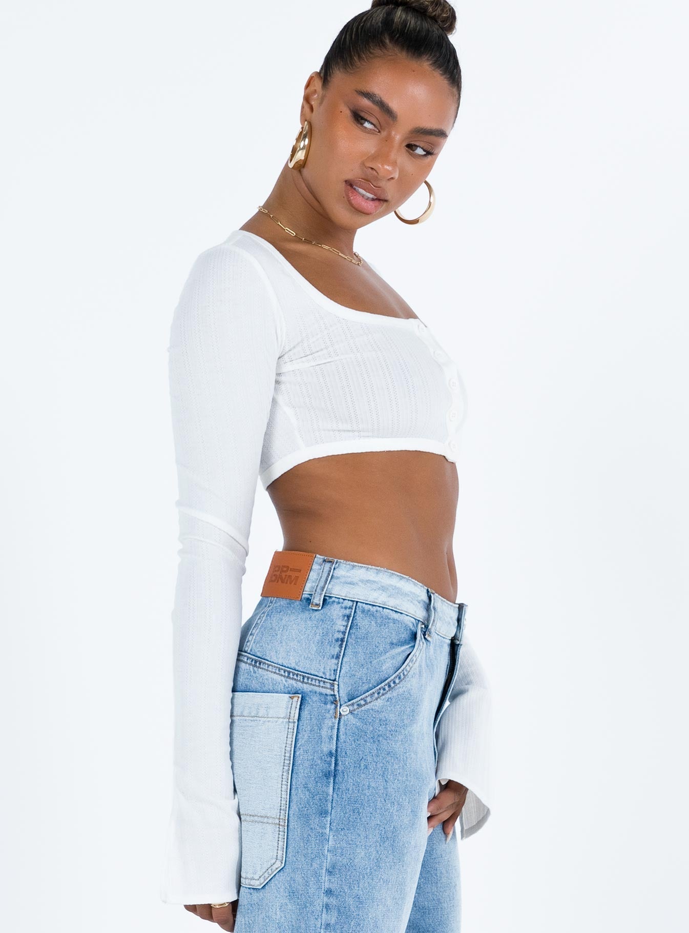 White long sleeve top Thin knit material Cropped design Scoop neck Front button fastening Flared sleeves Good Stretch Unlined 