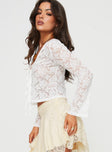 Lace Top Long sleeves slightly flared, sheer lace material, floral print, V-neckline  Two tie fastening at bust 
