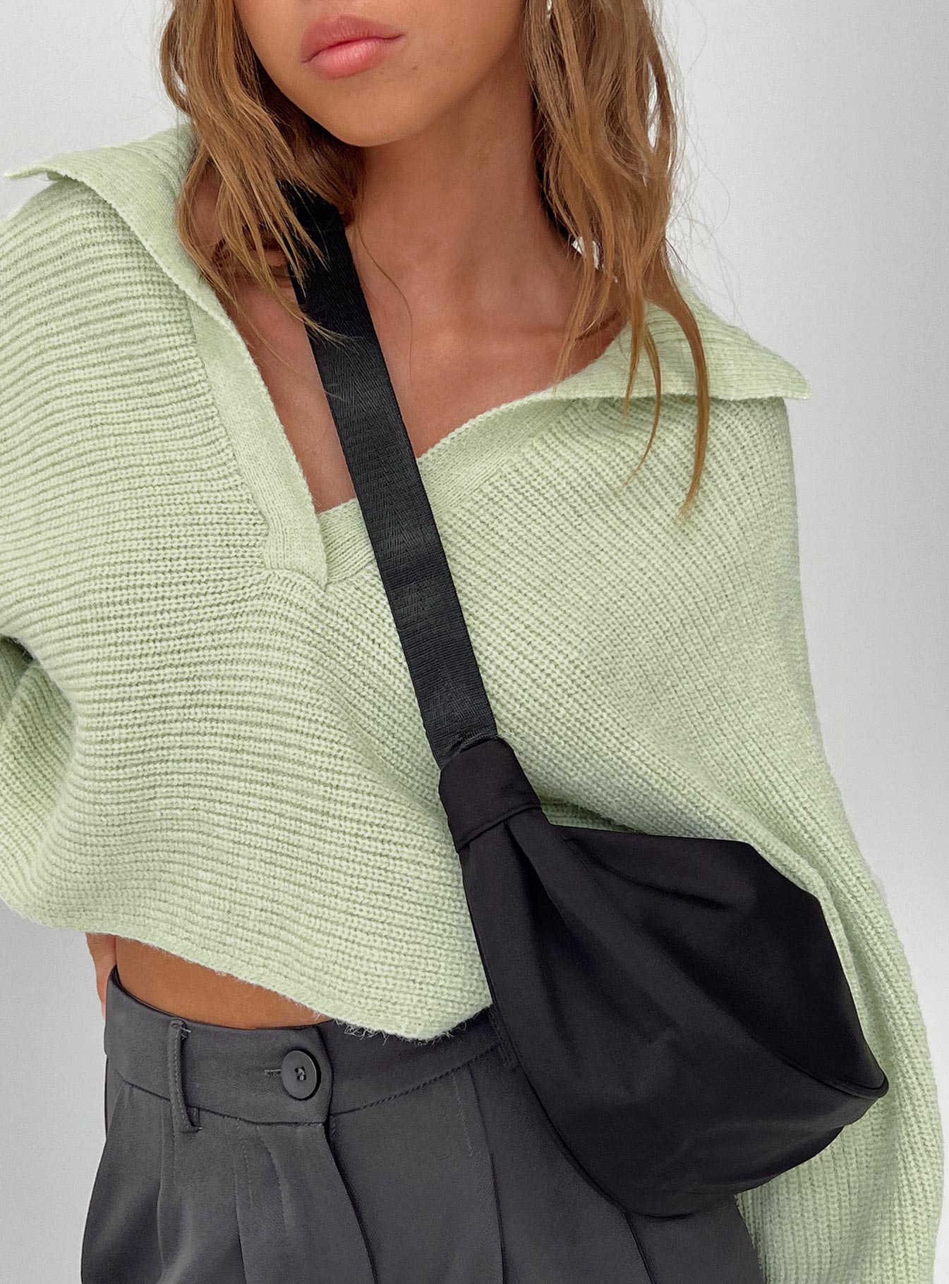 Black crossbody bag Nylon material Adjustable strap Zip fastening Internal slip pocket Silver toned hardware