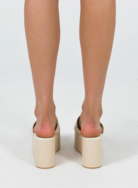 Platform slides Faux leather material Single thick upper Rounded toe Padded footbed