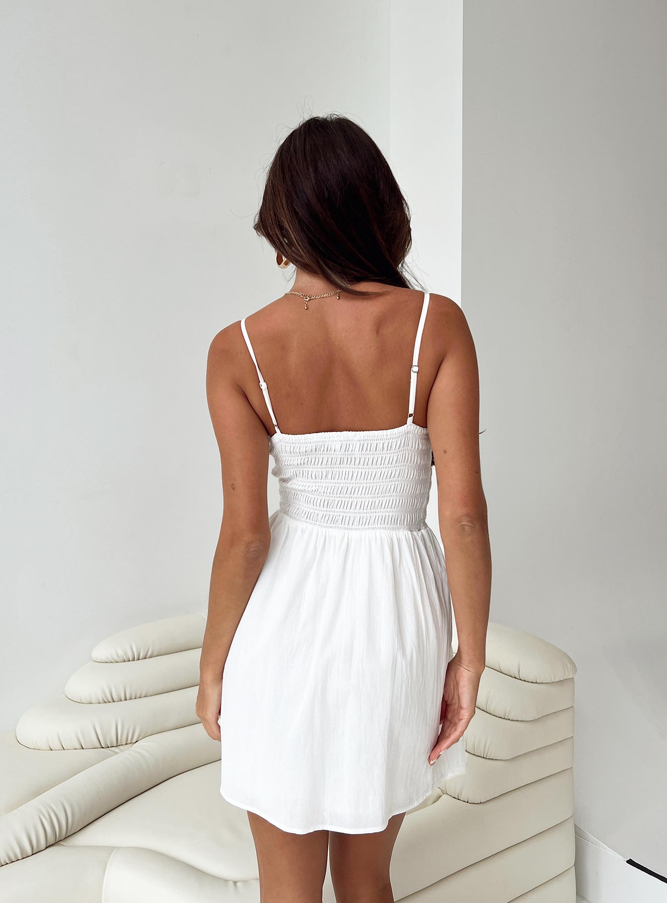 White mini dress Adjustable shoulder straps V neckline Fluffy trim Shirred waistband Ruched waist