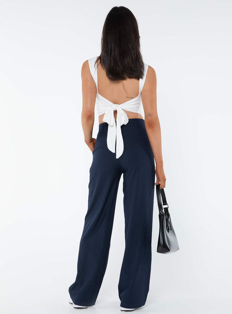 Tailored pants Front button and zip fastening, belt looped waist, subtle pleats at waist, twin hip pockets