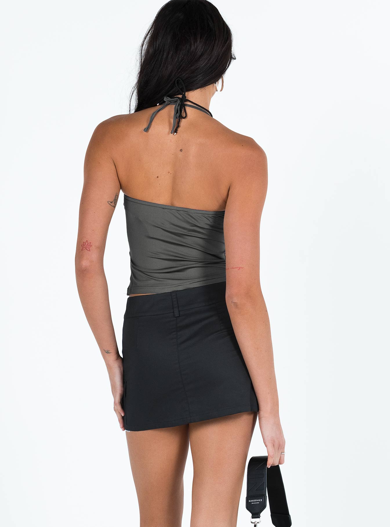 Black mini skirt Mid to low rise Double button and zip fastening Belt looped waist Four pocket design