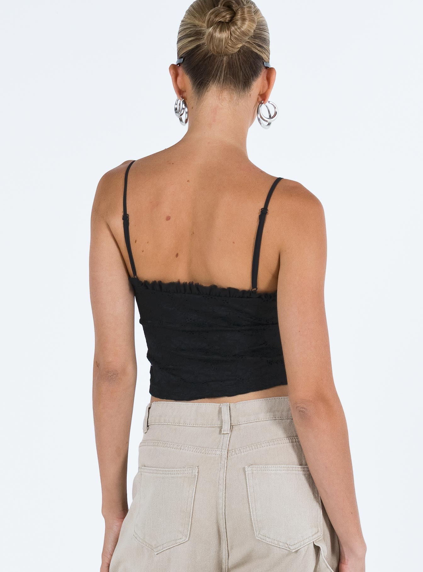 Crop top Lace material  Ruffle neckline  Adjustable shoulder straps  Inner silicone strip at bust  Lace up fastening at front Non stretch Fully lined 