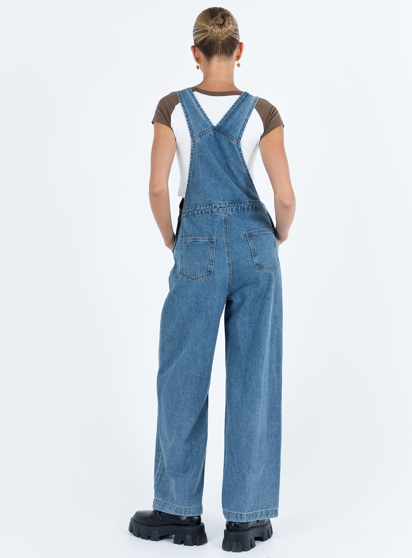 Overalls Mid wash denim Adjustable shoulder strap  Large chest pocket  Four classic pockets  Button fastening at hips  Wide leg