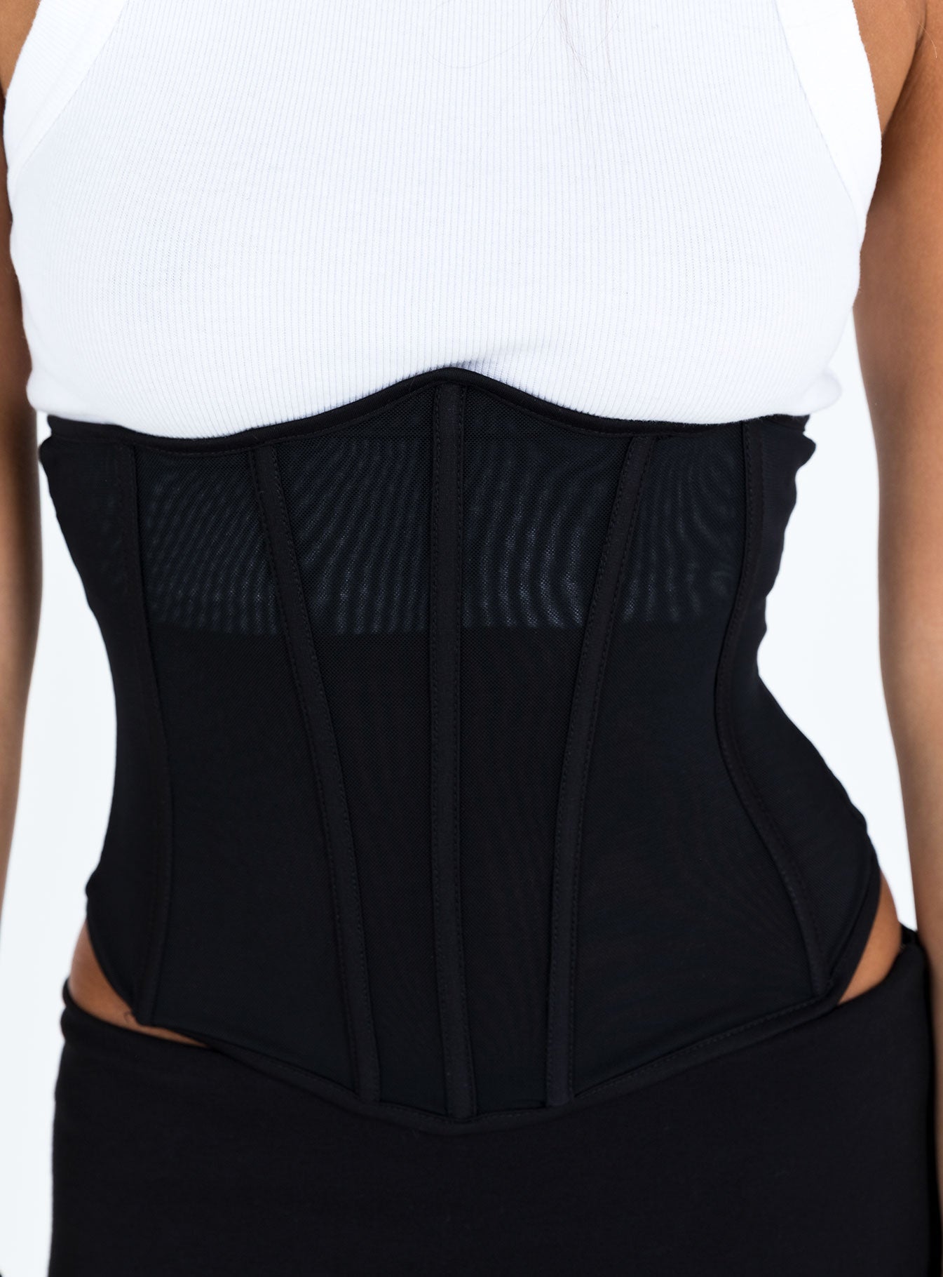 Black strapless corset Sheer mesh material Under bust design Pointed neckline Boning throughout Zip fastening at back Good stretch Mesh lined