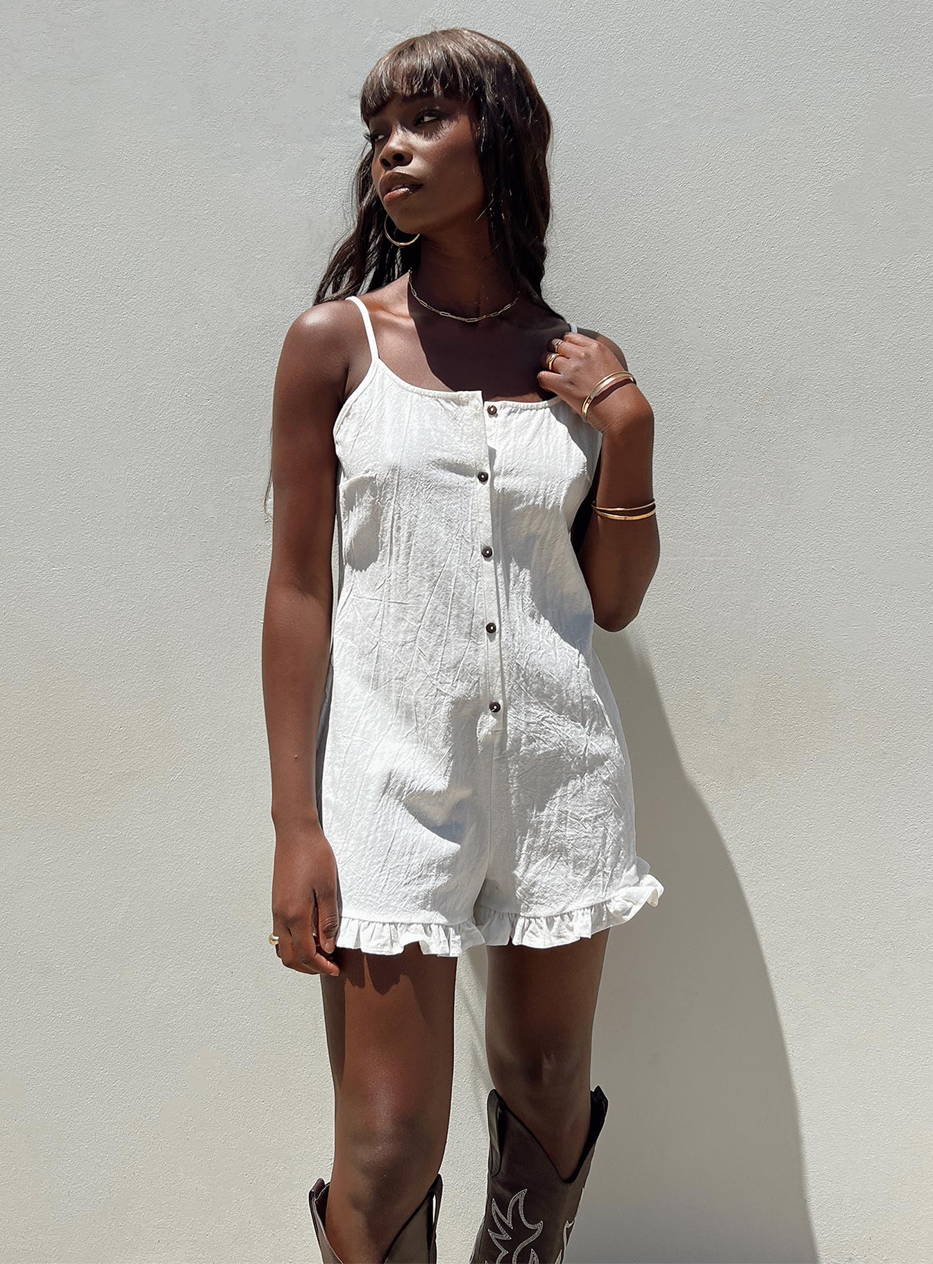 Playsuit Adjustable shoulder straps Scooped neckline Button fastening at front Frill hem Non-stretch