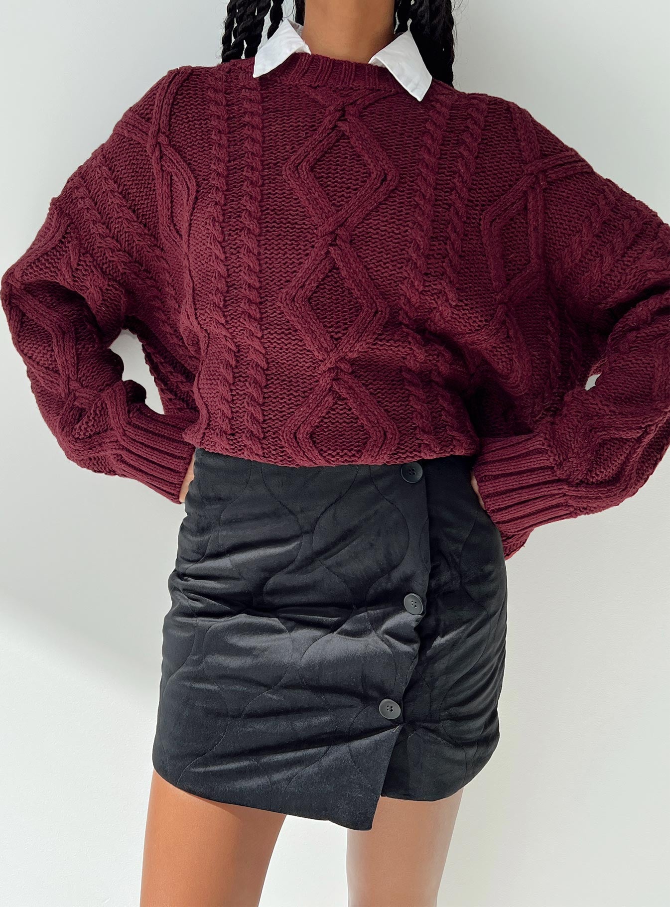 Black mini skirt Quilted material High rise Invisible zip fastening at back Button detail at front