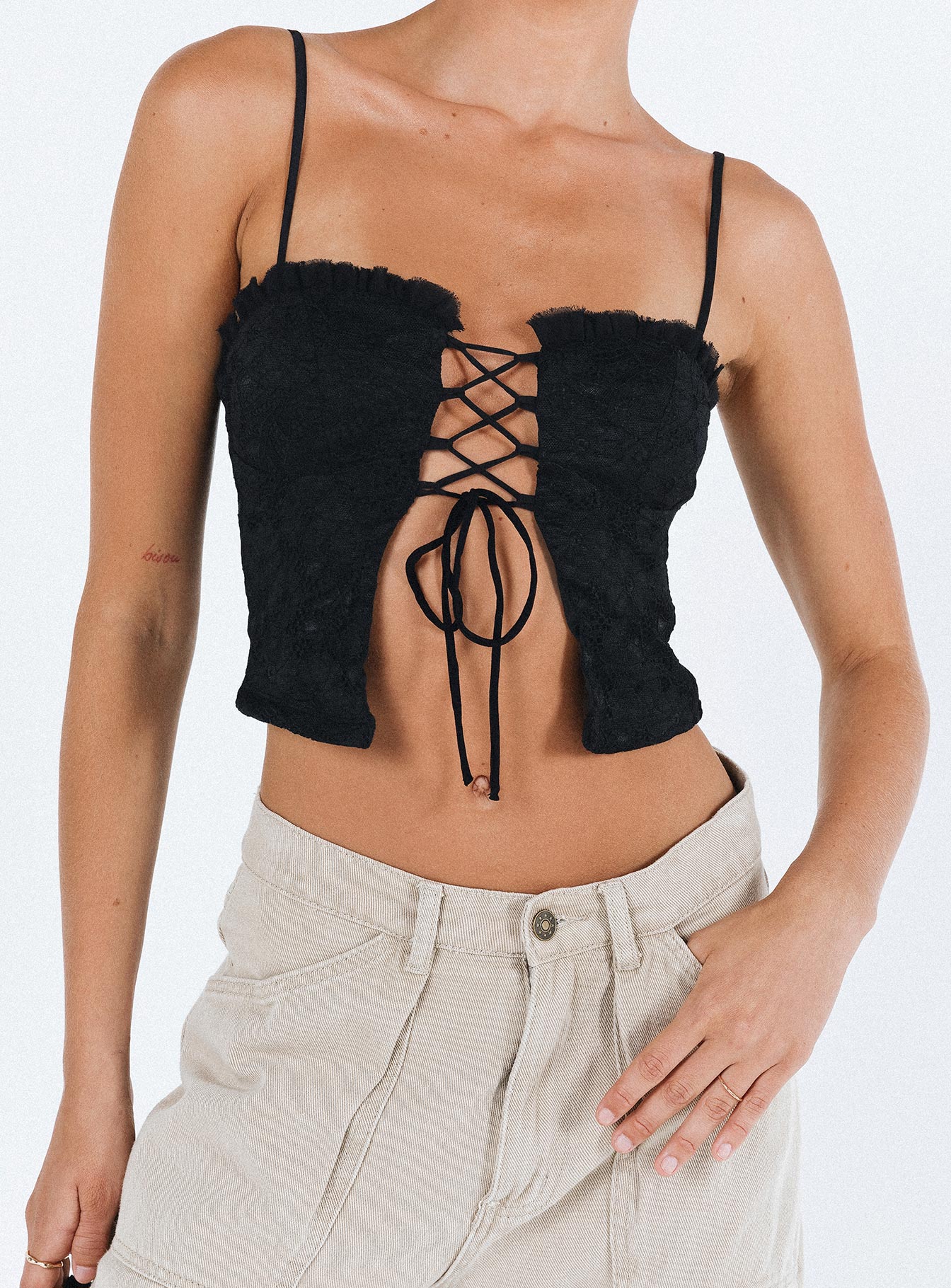 Crop top Lace material  Ruffle neckline  Adjustable shoulder straps  Inner silicone strip at bust  Lace up fastening at front Non stretch Fully lined 